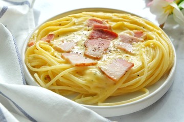 Close up of spaghetti carbonara on white plate.