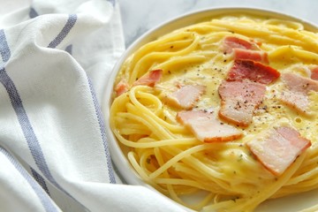 Close up of spaghetti carbonara on white plate.