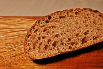 Top table of one brown slice, with dried wheat decoration on wooden table background