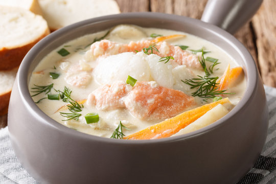 Norwegian creamy fish soup fiskesuppe with cod and salmon closeup. horizontal