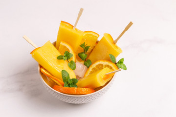 Fototapeta na wymiar Homemade orange popsicle with ripe orange and fresh mint