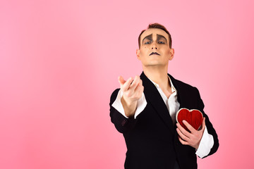Seems as a real love. Love confession on valentines day. Mime man hold red heart for valentines...