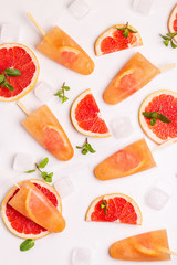 Homemade grapefruit popsicle with ripe grapefruit slices and fresh mint