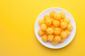 Cheese ball in a ceramic dish on yellow background. Top view.