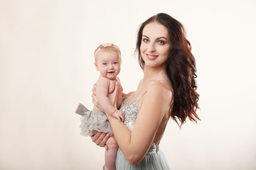 young attractive mother with a little girl on a light background