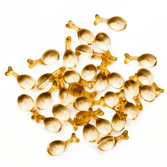 Gold capsules with serum for face. White background. Skin care, youth and beauty