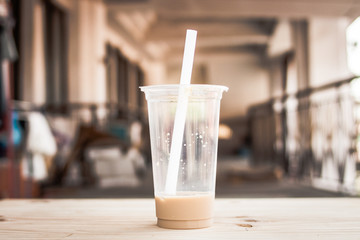 out of glass ice milk tea with boba on the wood table, The yummy drink