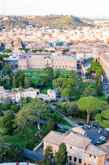 Fototapeta na wymiar High view on Rome cityscape with green and cozy Vatican gardens and museums on foreground