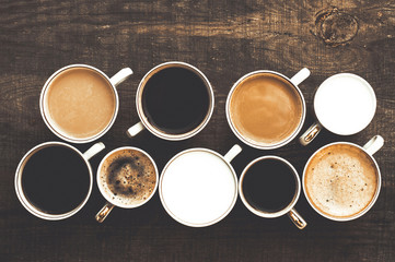 Many cups of coffee on a wooden table. Top view