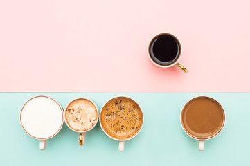 Many cups of coffee on a gently pink and turquoise background. Top view