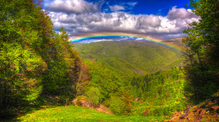 Landscape of Mavrovo national park with rainbow, mountain and lake in FYR Macedonia