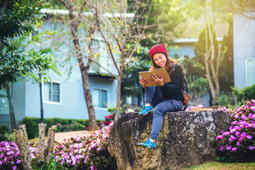 Naklejka na ściany i meble woman travel nature in the flower garden. relax sitting on rocks and reading books In the midst of nature at national park doi Inthanon...
