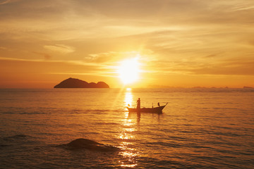 silhouette of man in the boat in a sea. Sunset. Thailand, Phangan