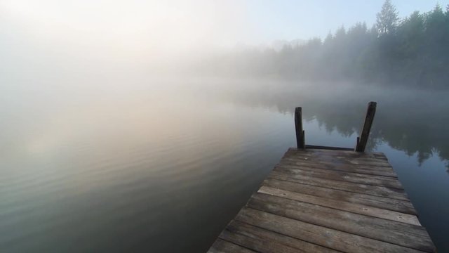 Sonnenaufgang mit nebel am See in den Bergen