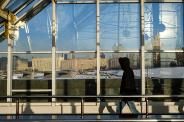 Naklejka premium People walking on the Bridge in Moscow. silhouette, lights and shadows.
