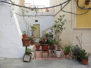 Fototapeta na wymiar little terrace with chairs and plantpots on the streets of Alicante