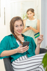 smiling young woman buying on internet with smartphone