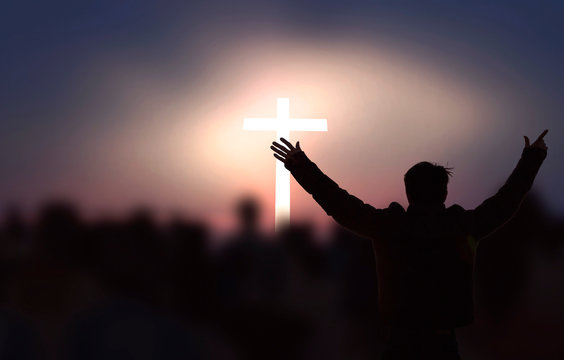  Concept of Jesus Christ: white cross on sunset sky background