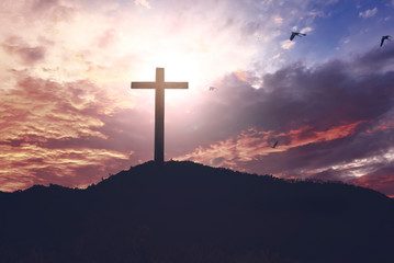  Concept of Jesus Christ: white cross on sunset sky background
