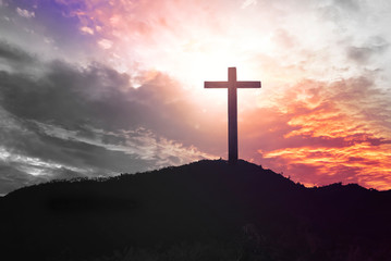 Concept of Jesus Christ: white cross on sunset sky background
