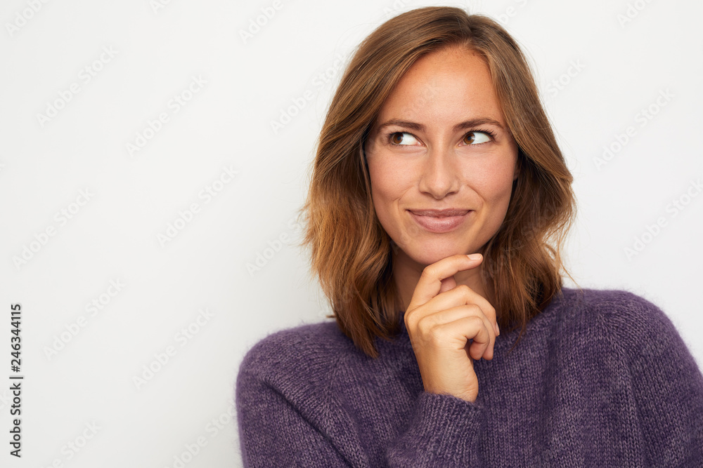 Wall mural portrait of a young happy woman smiling and thinking on white background