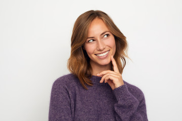 portrait of a young happy woman smiling and thinking on white background