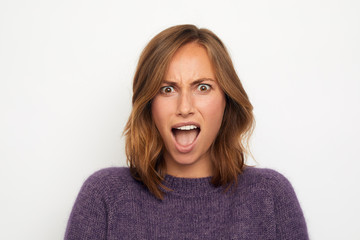 portrait of a young happy woman surpriced on white background © Martin Villadsen