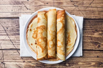 Foto op Plexiglas Thin pancakes on a plate. Wooden background. Close up. © Elenglush