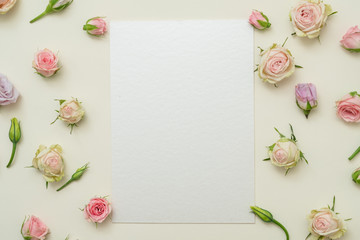 Spring holiday celebration. Blank paper sheet. Rose border decor on ivory background. Flat lay.