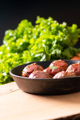 Food Homemade organic spicy meatball in iron cast on wooden background