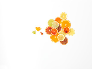 many fresh orange slices, lemon slices, lime slices, kumquat slices are nicely arranged on a white background