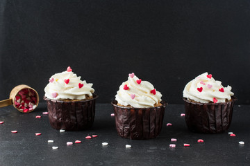 Vanilla cupcakes with white cream, sugar hearts for St. Valentine's Day
