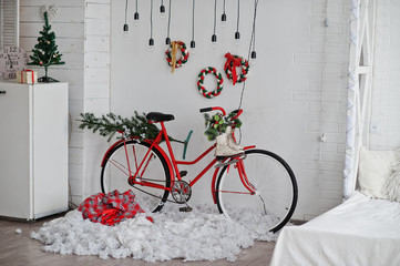 Fototapeta na wymiar Red decor bicycle with ice skates on Christmas decoration at studio.