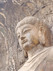 Fototapeta premium Luoyang Longmen grottoes. Broken Buddha and the stone caves and sculptures in the Longmen Grottoes in Luoyang, China. Taken in 14th October 2018