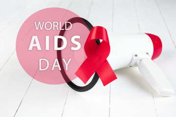 Aids Awareness Sign Red Ribbon with megaphone on wooden background . World Aids Day concept. The health, help, care, support, hope, illness, healthcare concept