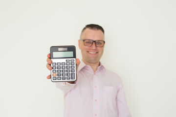 Positive banker advertising loan product. Young Caucasian man in office clothes and glasses showing calculator with empty screen. Finance or accounting concept
