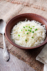 Sauerkraut with green onions in rustic bowl