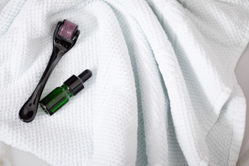 Dermaroller, Handtuch und grüne Beauty Serum Flasche zum  Microneedling für Anti Aging Lifting...