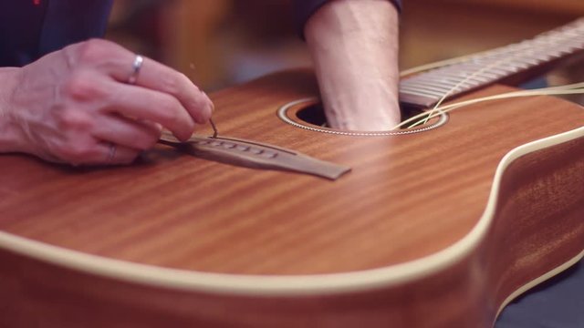 Guitar repair, man changes the strings