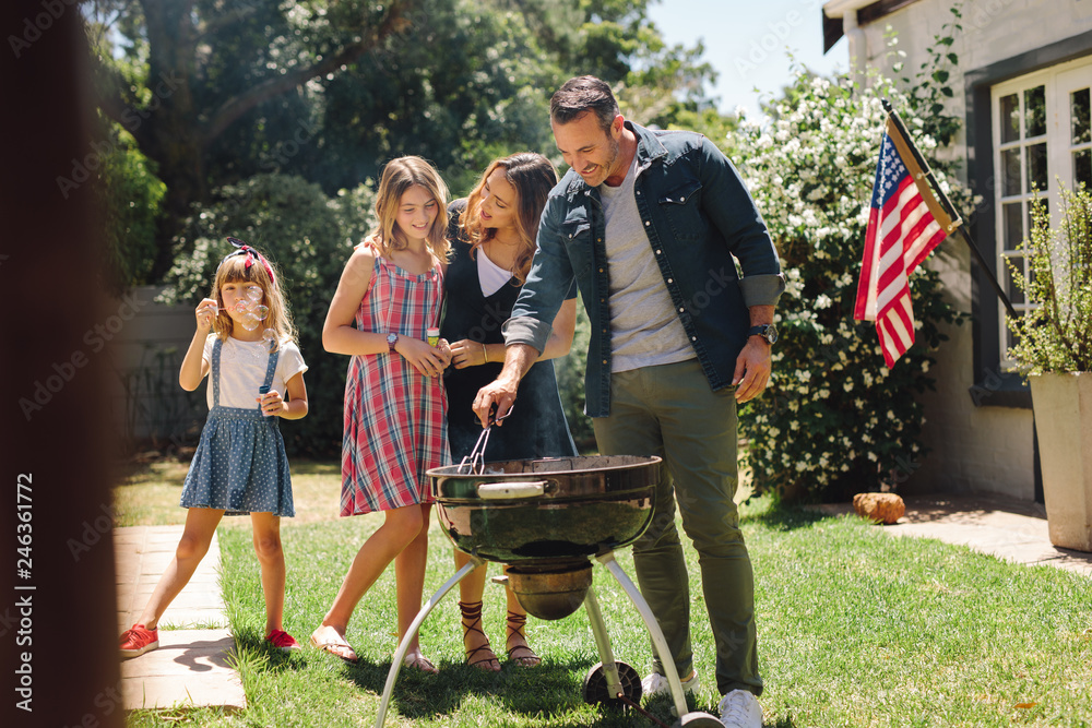 Wall mural family having fun cooking food together in the backyard