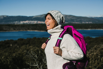 .Young and adventurous backpacker hiking in the mountains on a sunny winter day. Nature landscape...