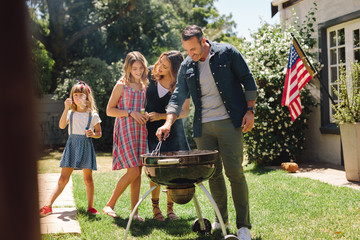 Family having fun cooking food together in the backyard