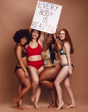 Diverse female group with every body is beautiful placard