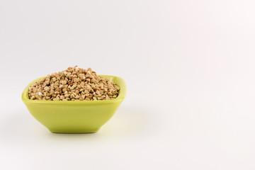 Natural fresh green buckwheat in bowl isolated on white background.