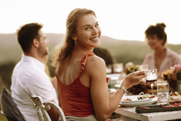 Beautiful woman having food with friends at party
