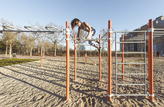 Woman training on parallel bars on street