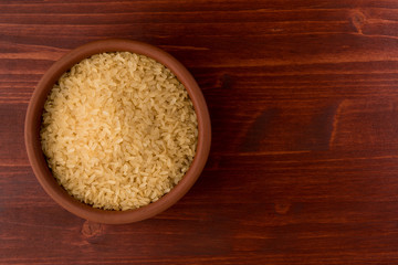 white rice in bowl on wooden table background