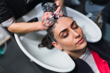 Hairdresser washing client's hair in salon