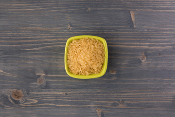 white rice in bowl on wooden table background