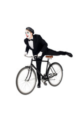 cheerful clown in suit riding bicycle isolated on white